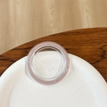 Close-up of a round clear phone socket with pink glitter inlay on a white plate - Magnetic Base - Ice Crushed - Brown