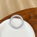 Close-up of a round glittery phone grip base with purple sequins on a wooden desk - Magnetic Base - Ice Crushed - Grey