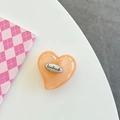 Nahaufnahme Herz-Handyhalterung aus orangefarbenem Glitzerharz mit Handmade-Metallplakette - Orange Glitzer