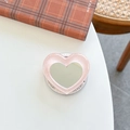 Macro shot of pink glitter heart phone grip with mirror on a cozy desk background - Pink