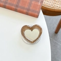 Macro view of brown glitter heart phone grip featuring a small built-in makeup mirror - Caramel