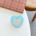 Glittery blue heart-shaped phone griptok with a built-in makeup mirror on a white table - Blue