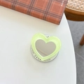 Close-up of glitter heart makeup mirror phone grip with Gift For You card on desk - Light Green