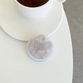 Macro detail of translucent glitter flower phone grip stand on a minimalist white desk - Gray