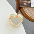 Detail of heart-shaped glitter phone grip with resin fruit slices and mirror center - Yellow
