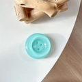 Macro shot of a mint green button phone grip with a polished semi-transparent resin finish - Crystal Deep Green