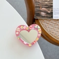 Detail of pink heart phone grip with fruit motifs and built-in vanity mirror on a table - Rose Red