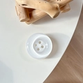 Détail macro d'un support de téléphone bouton blanc nacré avec accent bois épuré - Blanc Cristal