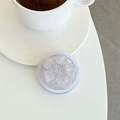 Vue détaillée d'un support de téléphone fleur violette pailletée sur une table blanche - Violet