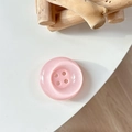 Gros plan sur le support de téléphone bouton rose avec finition nacrée et quatre trous - Rose Cristal