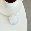 Gros plan du support de téléphone en forme de fleur pailletée sur un bureau blanc épuré - Blanc