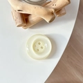 Macro view of creamy white pearlescent button phone grip on a natural wood block background - Crystal Creamy White