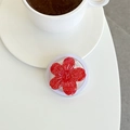 Macro shot of a red glitter resin flower phone socket on a white minimalist desk - Red