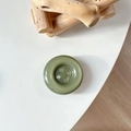 Detail of an olive green marble resin button phone grip with a smooth four-hole design - Crystal Dark Green