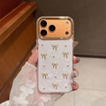Detail der iPhone Hülle mit 3D Goldschleife, Roségold Linsenschutz und Perlmuttoptik - Goldring-Weißer Glitzer-Epoxid-Goldperle Goldene Schleife / iPhone 17 Pro Max