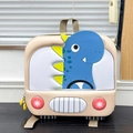 Close-up of hard shell kids backpack featuring a blue dinosaur car design on a window sill - Apricot