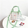 Dettaglio del fiocco in pizzo e del cuore rosso sulla borsa a quadri rosa per bambini - Verde