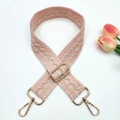 Gros plan d'une bandoulière rose style bohème avec broderie dorée et boucles métal - Boucle Dorée / Rose