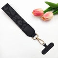 Detail of leopard print wrist strap with gold metal clasp and black phone tether tab - Black and Grey Leopard / With Gasket
