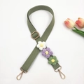 Macro detail of grass green woven bag strap with handmade crochet flower decorations - Green Strap With Multi-color Flowers