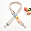 Detail of beige woven bag strap with colorful knitted flowers and gold metal hardware - Off-White + Colorful Flower