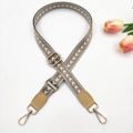 Close-up of adjustable geometric pattern woven shoulder strap with gold metal hardware - Light Khaki + Khaki Leather