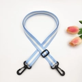 Detail of adjustable blue and white striped bag strap with durable black plastic hooks - Light Blue + Black Buckle