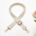 Macro detail of beige woven geometric bag strap with adjustable gold hardware - Beige Large V Pattern