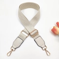 Detail view of cream white woven guitar strap with herringbone pattern and gold hooks - Off White