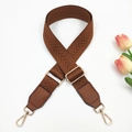 Close-up of brown chevron woven strap with leather ends and gold metal hardware - Brown