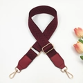 Macro detail of wine red chevron strap with gold buckles and faux leather ends - Burgundy
