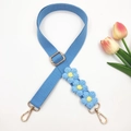 Detail of blue hand-woven bag strap with knitted daisy flowers and gold metal lobster clasps - Light Blue