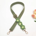 Detail of green woven bag strap featuring handmade crochet flowers and gold metal hardware - Bean Green