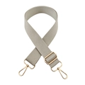 Detail eines verstellbaren hellgrauen Nylon-Taschenriemens mit goldener Metallschnalle - Goldschnalle / Beigegrau