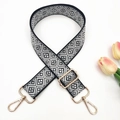 Close-up of black and white geometric jacquard bag strap with gold metal hardware - Black Light Grey