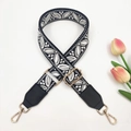 Close-up of jacquard bag strap with floral pattern, leather ends and gold metal hooks - Black Light Grey + Black Leather
