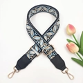 Close-up of ethnic jacquard shoulder strap with gold metal hooks and floral accents - Black Light Blue + Black Leather