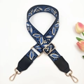 Close-up of bohemian floral jacquard bag strap with leather ends and golden metal clips - Black Lake Blue + Black Leather