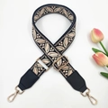 Close-up of ethnic floral jacquard bag strap with black leather ends and gold hardware - Black Light Pink + Black Leather