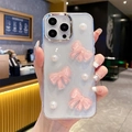 Detail showing 3D pink silk bows and white pearls on a translucent iPhone case - iPhone 7/8/SE 2020 / Pink