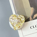Detail view of heart-shaped phone grip with yellow sequins and handmade label - Magnetic Colorful Sequin Heart Style No.10