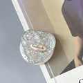 Macro detail of heart-shaped phone grip featuring silver glitter and handmade logo plaque - Magnetic Colorful Sequin Heart Style No.16