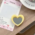 Detail van een gele hartvormige draagbare spiegel en mobiele telefoonhouder-accessoire - Lichtgeel