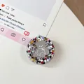 Detailopname van ronde telefoonhouder met zilveren beertje en kleurrijke glitters - Kleurrijke Berenspiegel Nr. 2