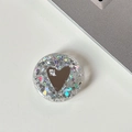 Close-up of a round glitter phone socket with a heart mirror and 'mine.' text detail - Transparent Stand - Colorful Sequins Heart Mirror - No. 16