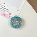Macro-opname van griptok telefoonhouder met blauwgroene lovertjes en zilveren beer - Kleurrijke Berenspiegel Nr. 3