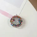 Detail van ronde hars telefoonhouder met grijze beer en kleurrijke glitter pailletten - Kleurrijke Berenspiegel Nr. 5