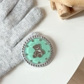 Detailed view of mint green bear phone grip with rhinestones on a knitted backdrop - Dark Green (Jelly Bear Mirror / White Zirconia)