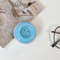 Detail shot of a light blue button shaped phone grip on a minimalist desk setup - Magnetic Large Button / Crystal Solid Color-Blue