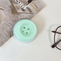 Detail shot of a mint green button-shaped collapsible phone socket on a desk - Magnetic Large Button / Crystal Solid Color-Light Green